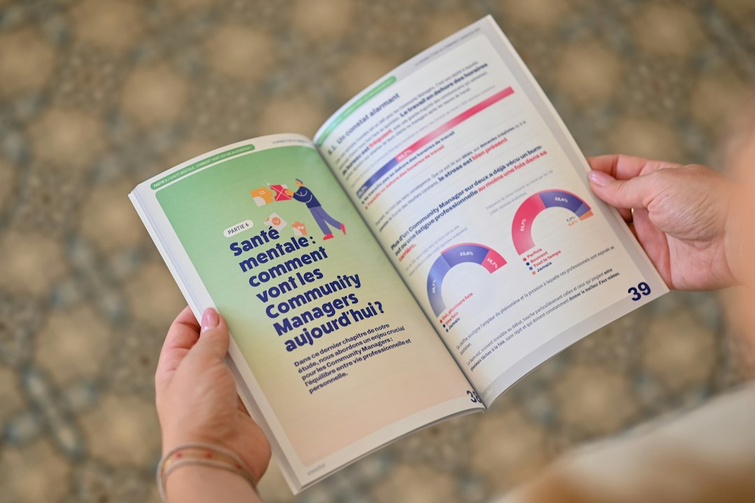Person holding an open booklet with text and charts
